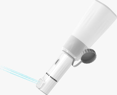Anawnas Pro5 portable electric bidet inverted with a water bottle attached, demonstrating water spray from the nozzle.